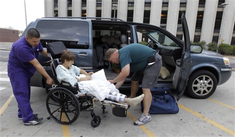 Tim Brunn of Island Lake, Ill., helps his son, Josh, into their van after he was released from the hospital Thursday in Indianapolis. Josh along with his mom, Karen, were injured when a stage collapsed at the Indiana State Fair on Aug. 13. 